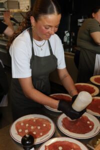 Kok anretter carpaccio på Petit Prix tallerkener i restaurantens åbne køkken